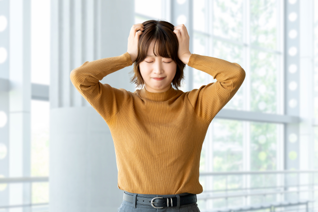 住宅や暮らしの悩みを抱えて頭を抱える女性